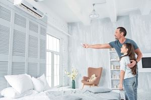 father helping his daughter set the air conditioner
