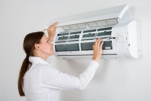 a woman learning to check the freon in a home air conditioner