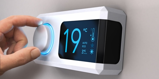 A white digital thermostat with a blue illuminated dial set to 19 degrees Celsius.