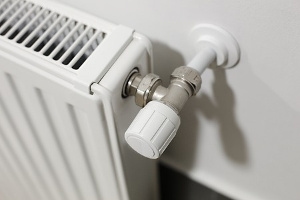 A white radiator with a thermostat valve.