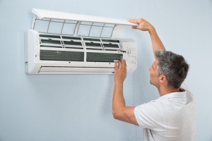 A man checking the air conditioner unit.
