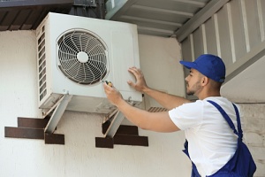 a man looking at a split system air conditioner on a home