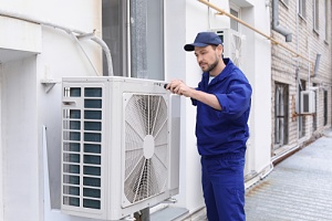 worker installing air conditioning for the summer