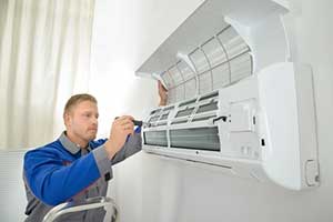 HVAC contractor preparing air conditioner for the summer