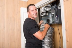 Ventilation system being properly installed by a NATE certified HVAC contractor who stopped to smile at the camera in Fairfax, VA 