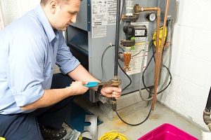 technician performing a furnace installation of a gas furnace