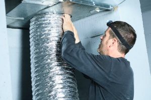 HVAC contractor performing duct work cleaning in a person's home