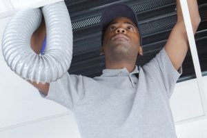 A technician that is NATE certified working on an air conditioning system practicing safety and using proper tools for the job.