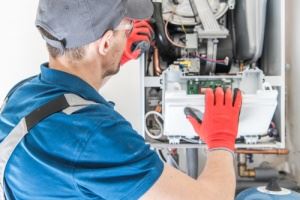 A technician working on a white gas furnace