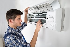 HVAC contractor inspecting air conditioning unit in Gaithersburg, MD to make sure it will work during the summer
