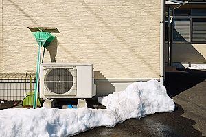 a heating system that was covered in snow during the winter months and needs repair from HVAC contractors