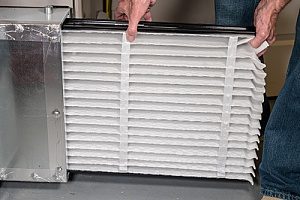an air filter being replaced for a high efficiency condensing furnace