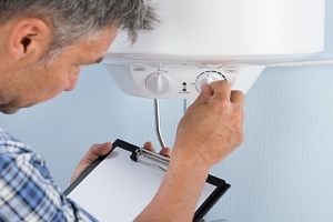 man checking the thermostat on the home heating system