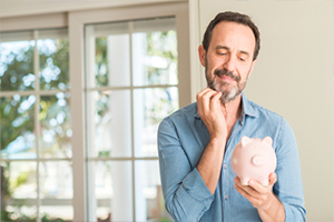 Middle age man save money holding piggy bank