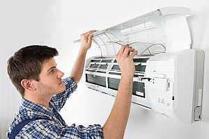 a professional HVAC contractor conducting regularly scheduled air conditioning maintenance within a Gaithersburg, MD home