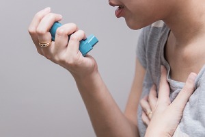 a woman holding a bronchodilator. The Symptoms Of Bad Air Quality In The Home can vary