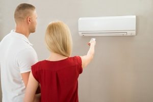 young couple trying to get their brand new air conditioning unit to work
