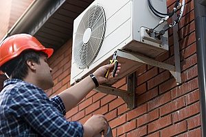 a Gaithersburg, MD HVAC contractor working on an outdoor HVAC unit to increase the indoor air quality in the home