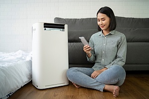 Woman turning on her dehumidifier